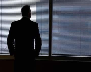 The director of The Visa Canada is standing in his office glancing through window