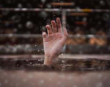 A drowning man's hand representing humanitarian & Compassionate (H&C) need