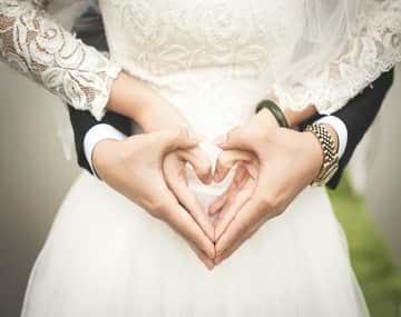 Spouses are making the heart sign with their hands after successful Spousal Sponsorship application